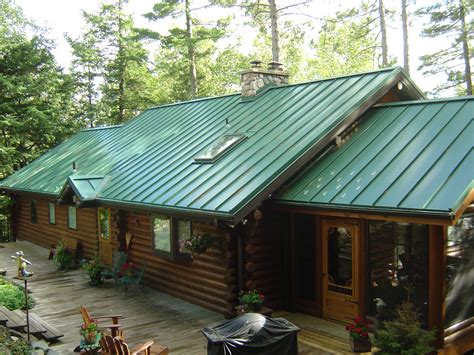 white house with green metal roof|cabin with green metal roof.